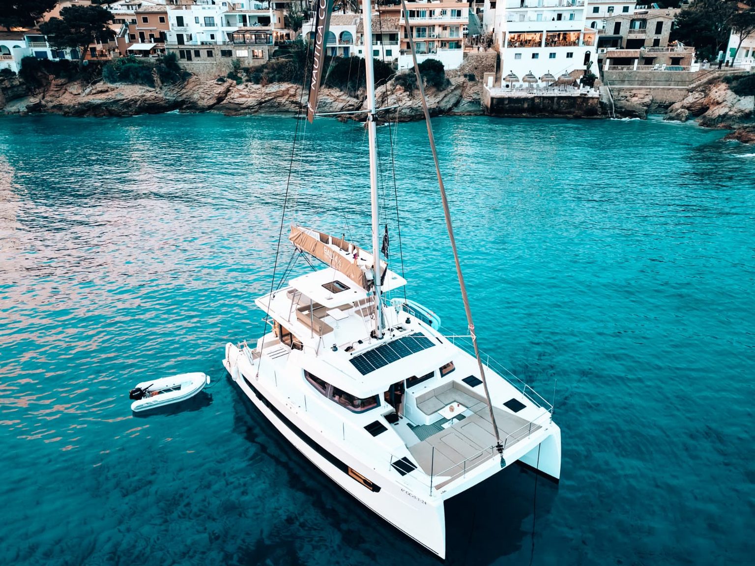 A catamaran anchored in clear turquoise water off Mallorca