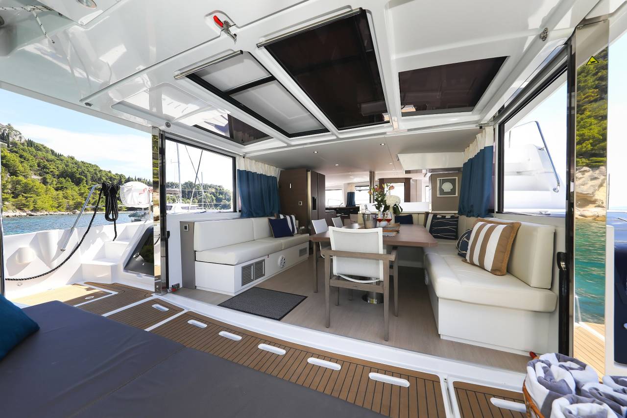 The saloon of a catamaran opening onto the aft deck